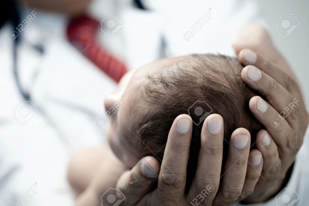 Pediatrician holding a newborn — natural colic relief